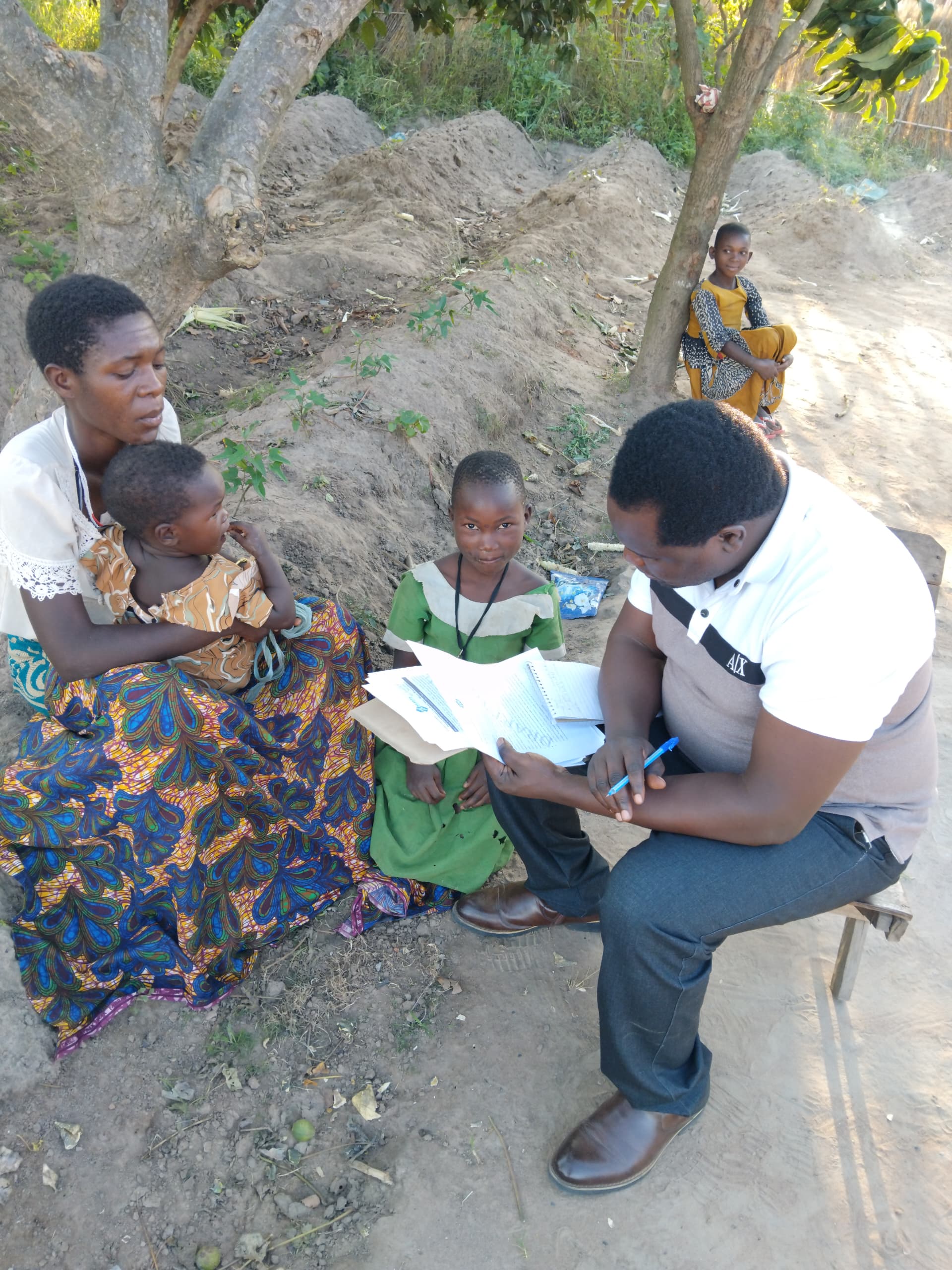 Enumerator entering responses while child plays nearby